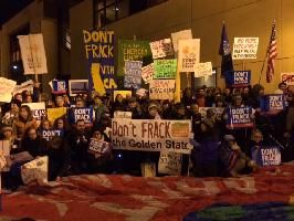 Crowd holding signs against fracking